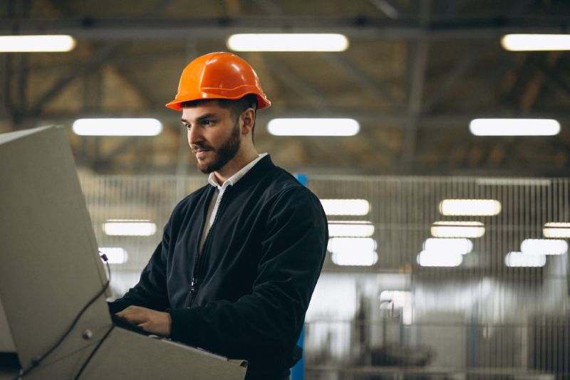 factory worker wearing orange safety helmet