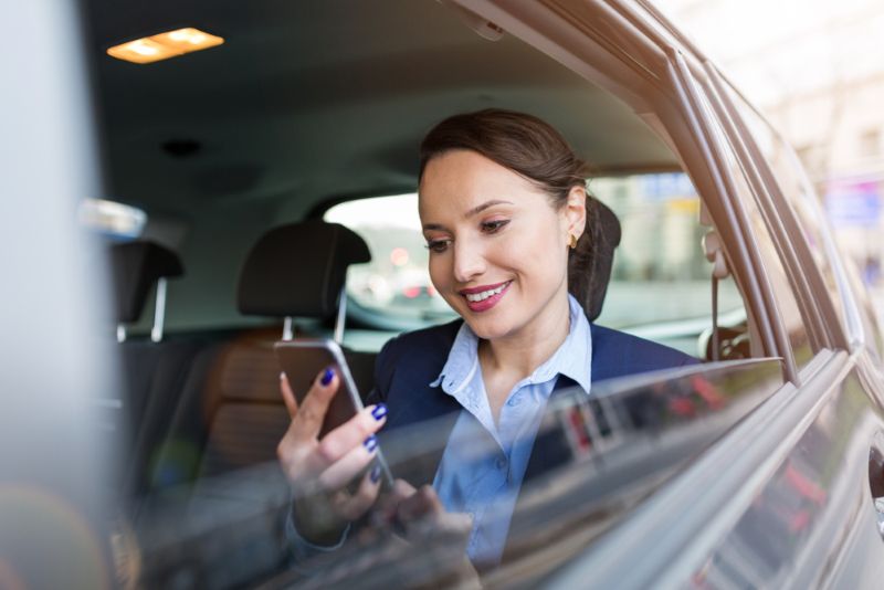 Woman using cell phone in back seat of a car